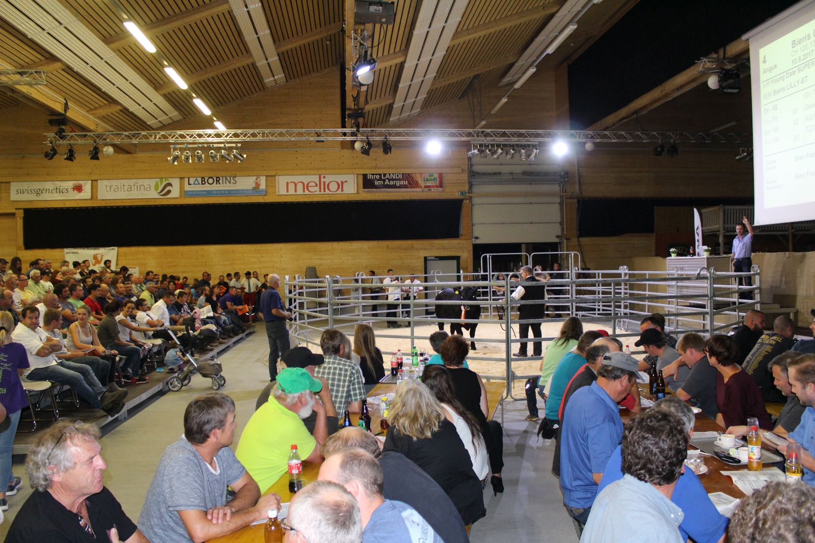 Public dans la Vianco Arena autour du ring de présentation, où un taureau Angus est actuellement présenté.