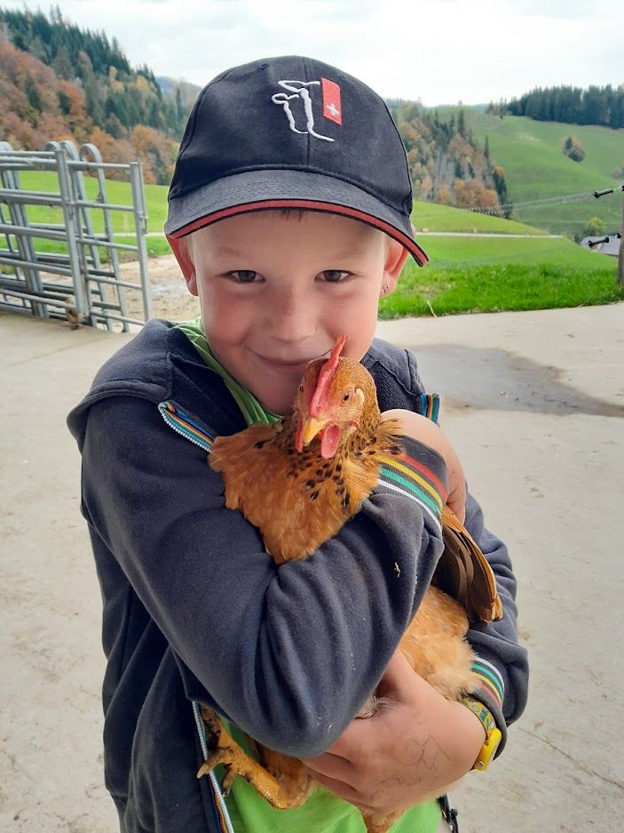 Daniel's son with a chicken in his arms.